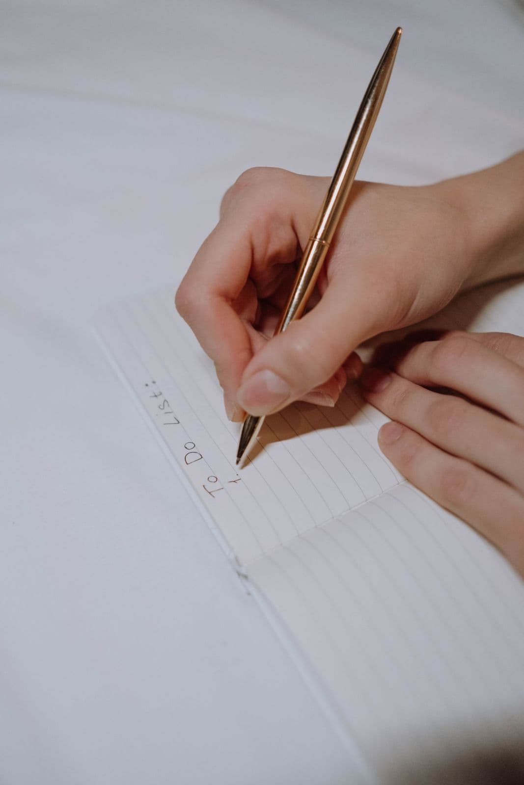 Mano che compila a penna una checklist su un quaderno